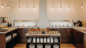 A breakfast buffet with various pastries and coffee options.