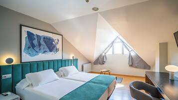 Una habitación de hotel moderna con una cama grande, un escritorio y un cuadro en la pared.