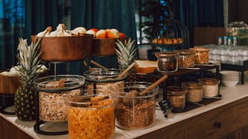 Buffet com diversas opções de comida e uma saladeira de frutas.