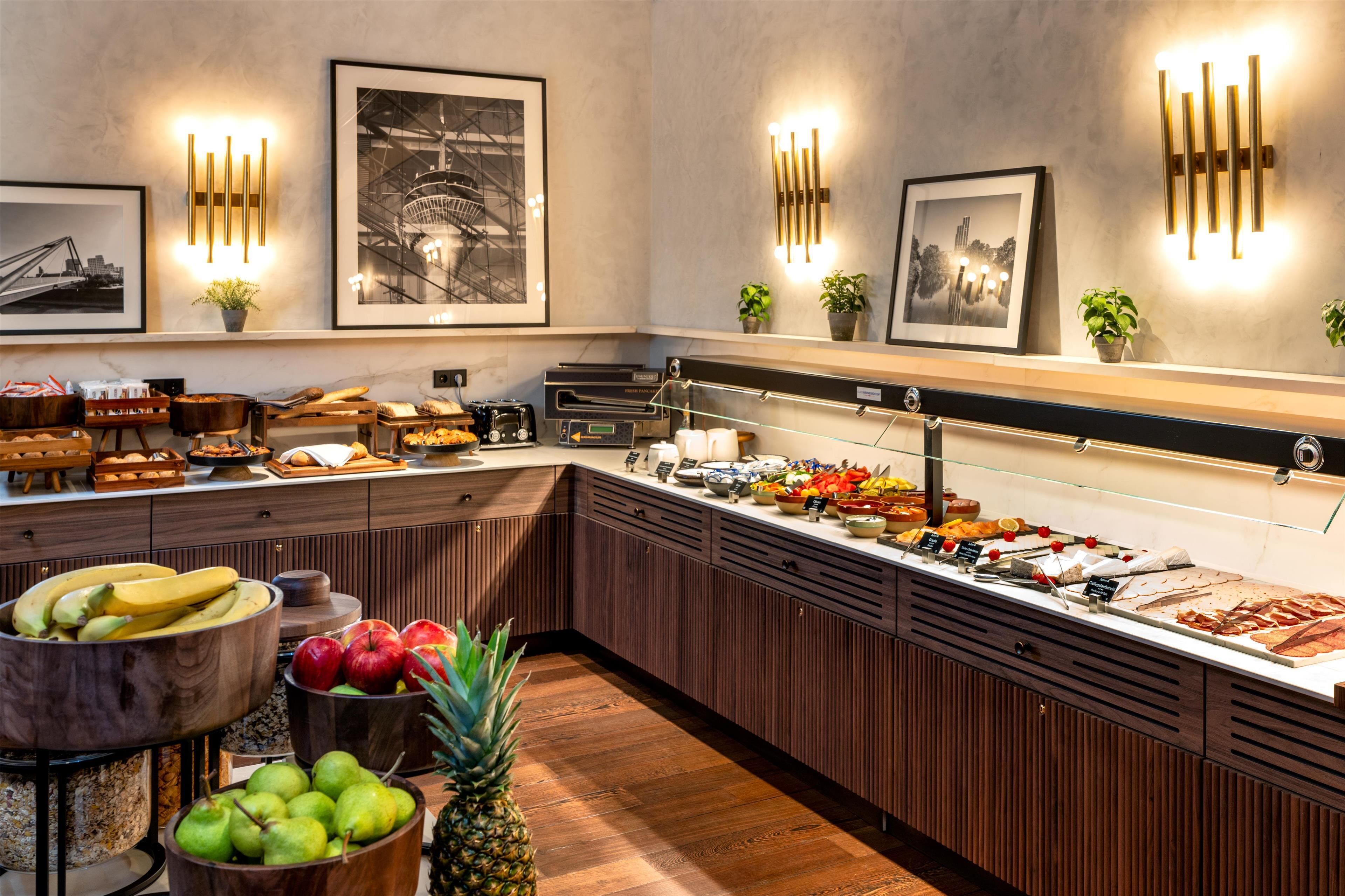 A buffet area with various food items, wooden cabinets, and wall-mounted light fixtures.