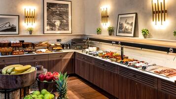 A buffet area with various food items, wooden cabinets, and wall-mounted light fixtures.