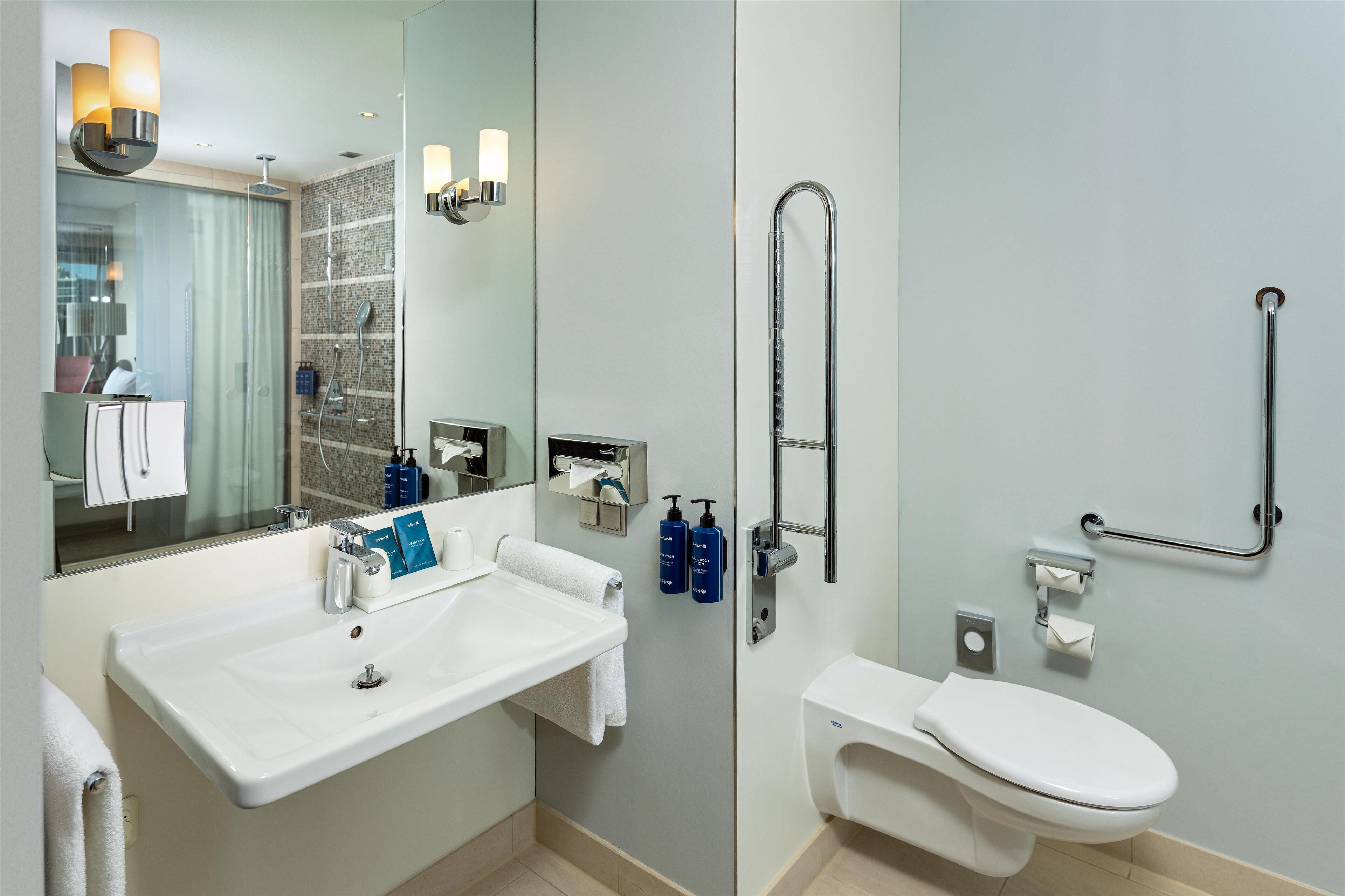 Een moderne badkamer met een wastafel, spiegel en toilet.