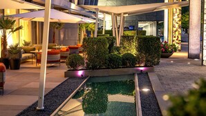 A modern hotel courtyard with a pool, outdoor seating, and well-maintained landscaping. - Radisson Blu Media Harbour Hotel, Düsseldorf (Düsseldorf)
