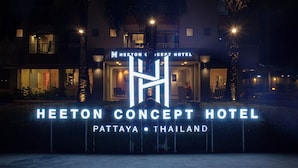L'esterno dell'Heeton Concept Hotel a Pattaya, Thailandia, con insegne illuminate e una facciata moderna.