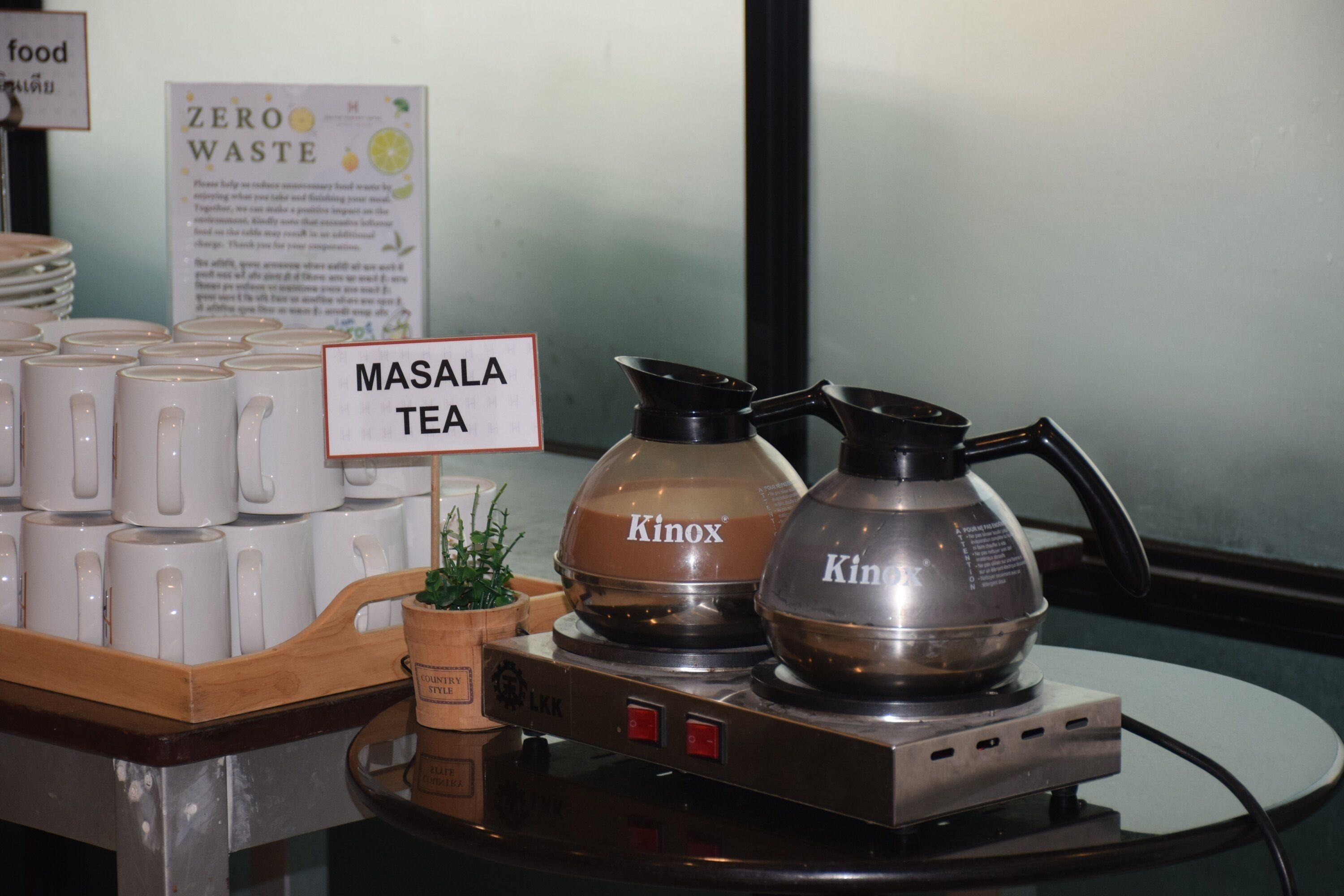 A display of Masala Tea with two Kinox branded coffee makers on a table.