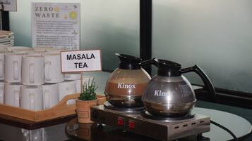 A display of Masala Tea with two Kinox branded coffee makers on a table.