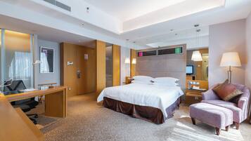 A hotel room with a bed, a desk, a chair, a TV, and a mirror.