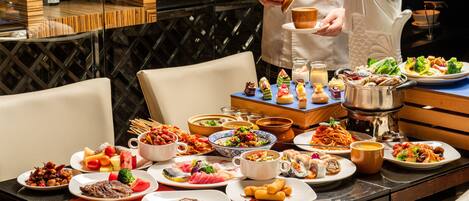 A dining table with various dishes and a chef serving food.