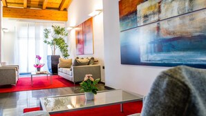 A modern living room with a glass coffee table, a sofa, and a red carpet. - Hotel Gallia (Pianezza)