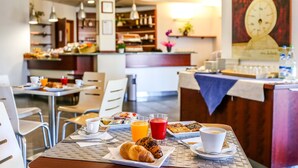 A breakfast setting with tables, chairs, and a variety of food and drink items. - Hotel Gallia (Pianezza)