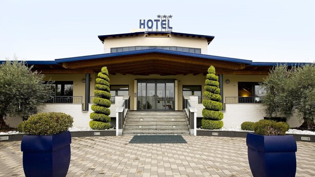 A hotel entrance with a sign, steps, and two large planters. - Hotel Gallia (Pianezza)