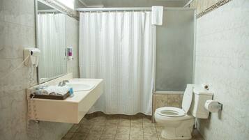 Ein Badezimmer mit Waschbecken, Spiegel, Toilette und Duschvorhang.