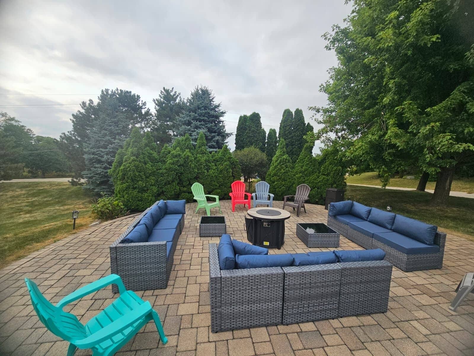 An outdoor patio area with wicker furniture, including sofas and chairs, and a round table.