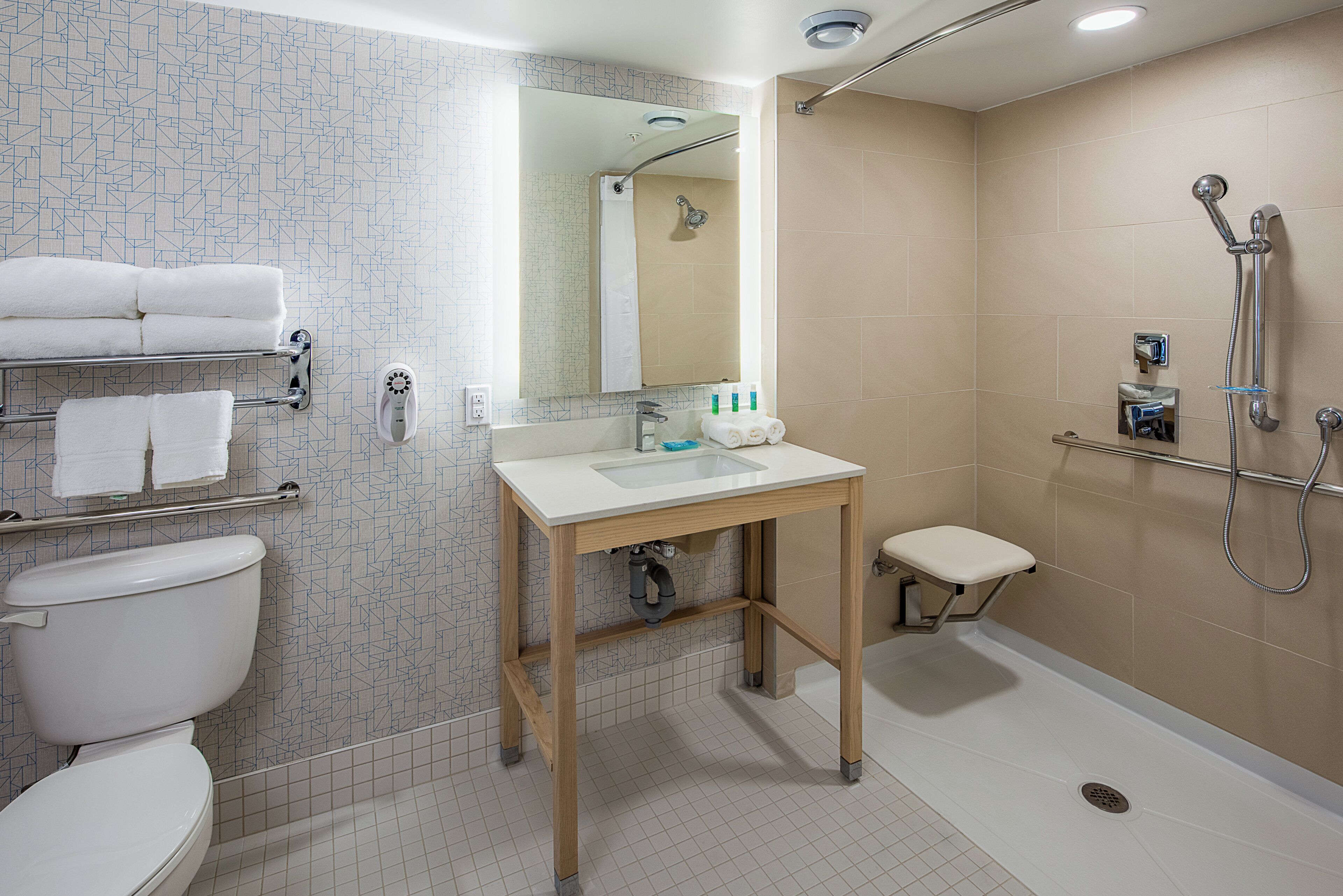 Egy modern fürőszoba, amelyben WC, mosdókagyló és zuhanyzó található.
