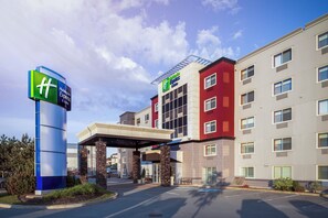 Un hotel Holiday Inn Express con ingresso coperto, diversi piani e un parcheggio.