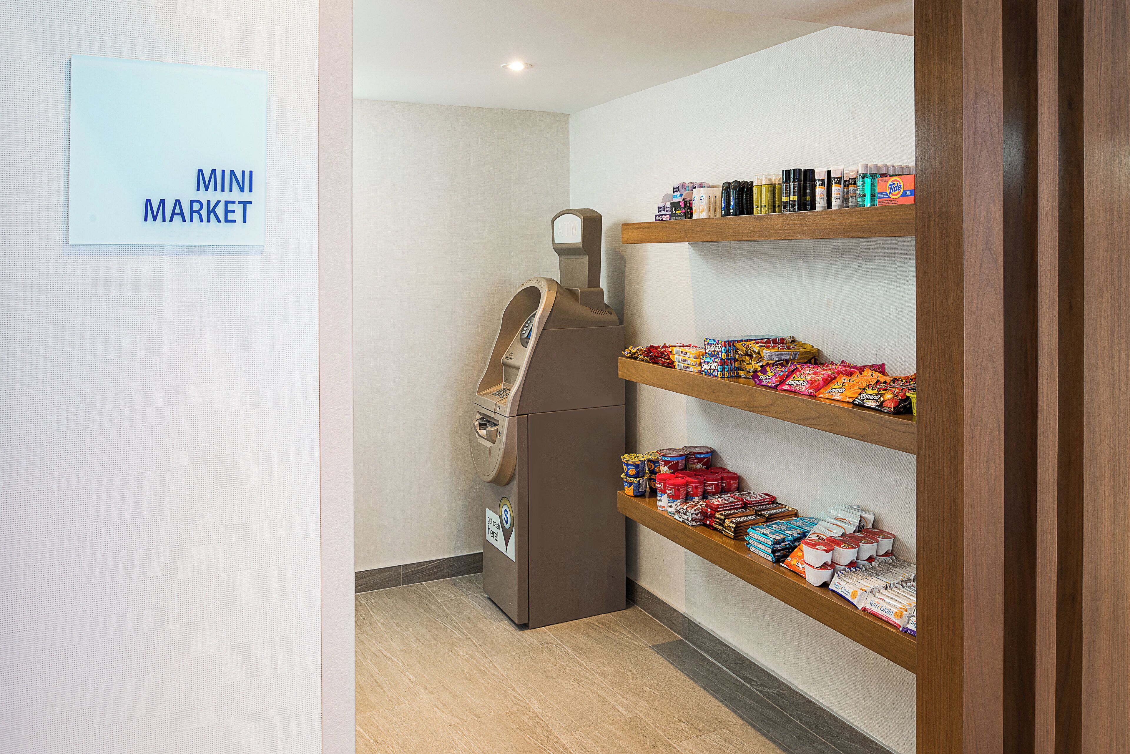 Een kleine supermarkt met schappen vol snacks en drankjes.