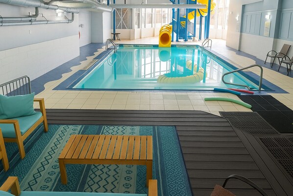 An indoor swimming pool with a slide, a wooden bench, and a patterned rug. - Holiday Inn Express & Suites Halifax - Bedford by IHG (Halifax)