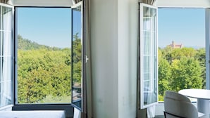 A room with a large sliding glass door leading to a balcony, a bed, and a round table with a chair. - Bellavista Terme Resort & Spa (Montegrotto Terme)