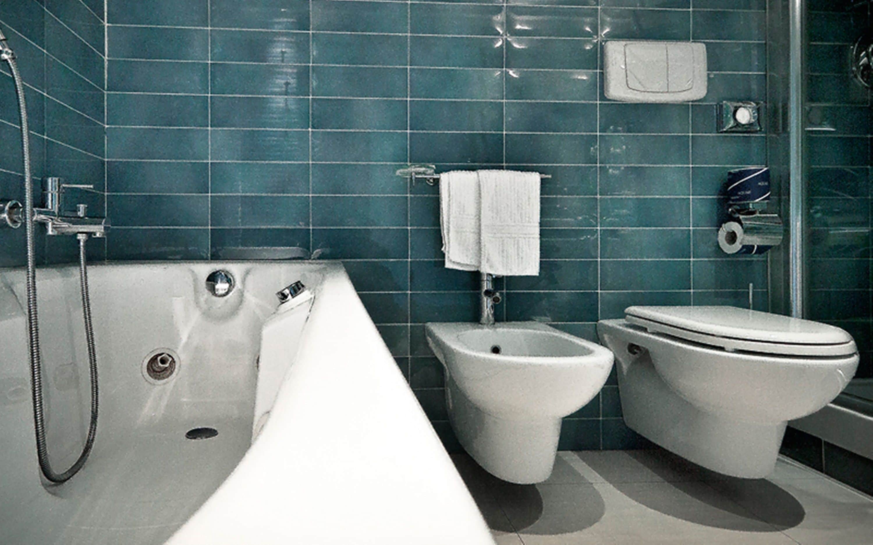 A bathroom with a bathtub, bidet, and toilet.