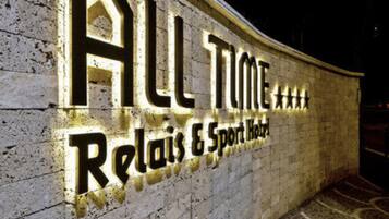 Una pared con iluminación que muestra el texto "ALL TUNE Relax & Sport Hotel".