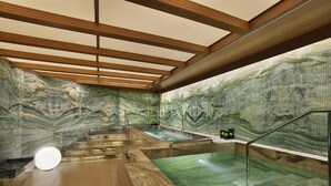 A spa area with a wooden ceiling, a large bathtub, and a green marble wall. - Shangri-La Eros, New Delhi (New Delhi)