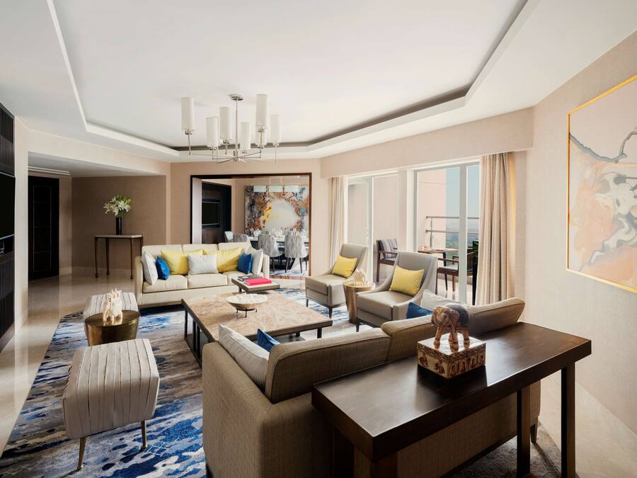 A spacious living room with a sofa set, a coffee table, and a dining area with chairs.