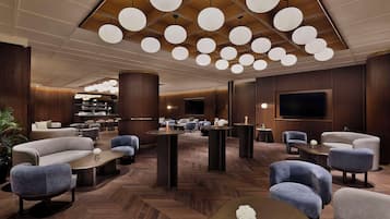 Eine moderne Lobby mit Sofas, Tischen und einem Fernseher.