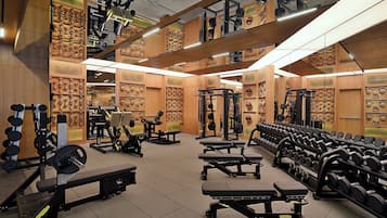 A gym with various exercise equipment, including benches, dumbbells, and weight machines.