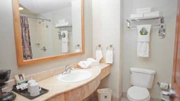 A bathroom with a sink, mirror, toilet, and towel rack.