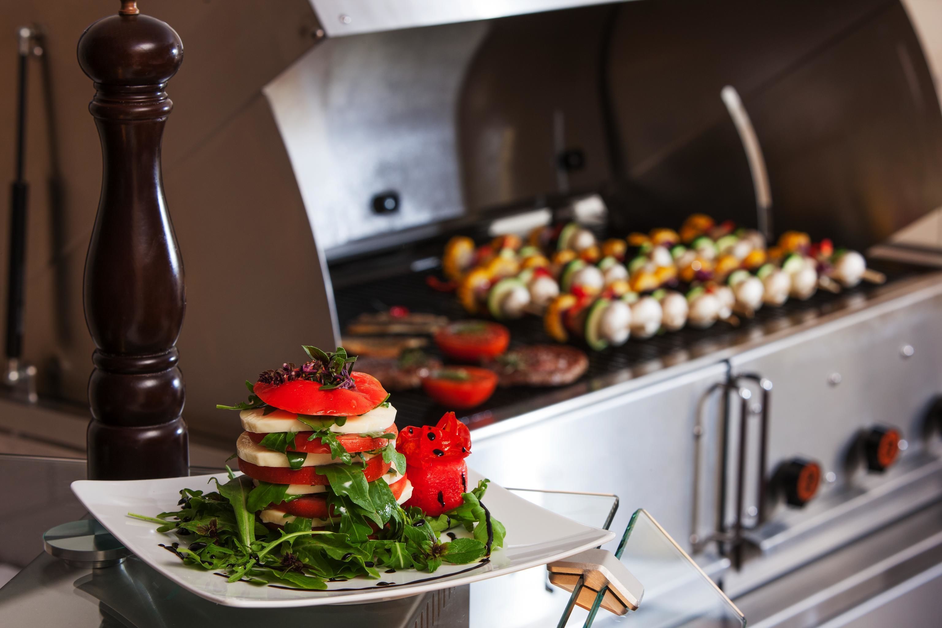 A kitchen with a grill and a plate of food.