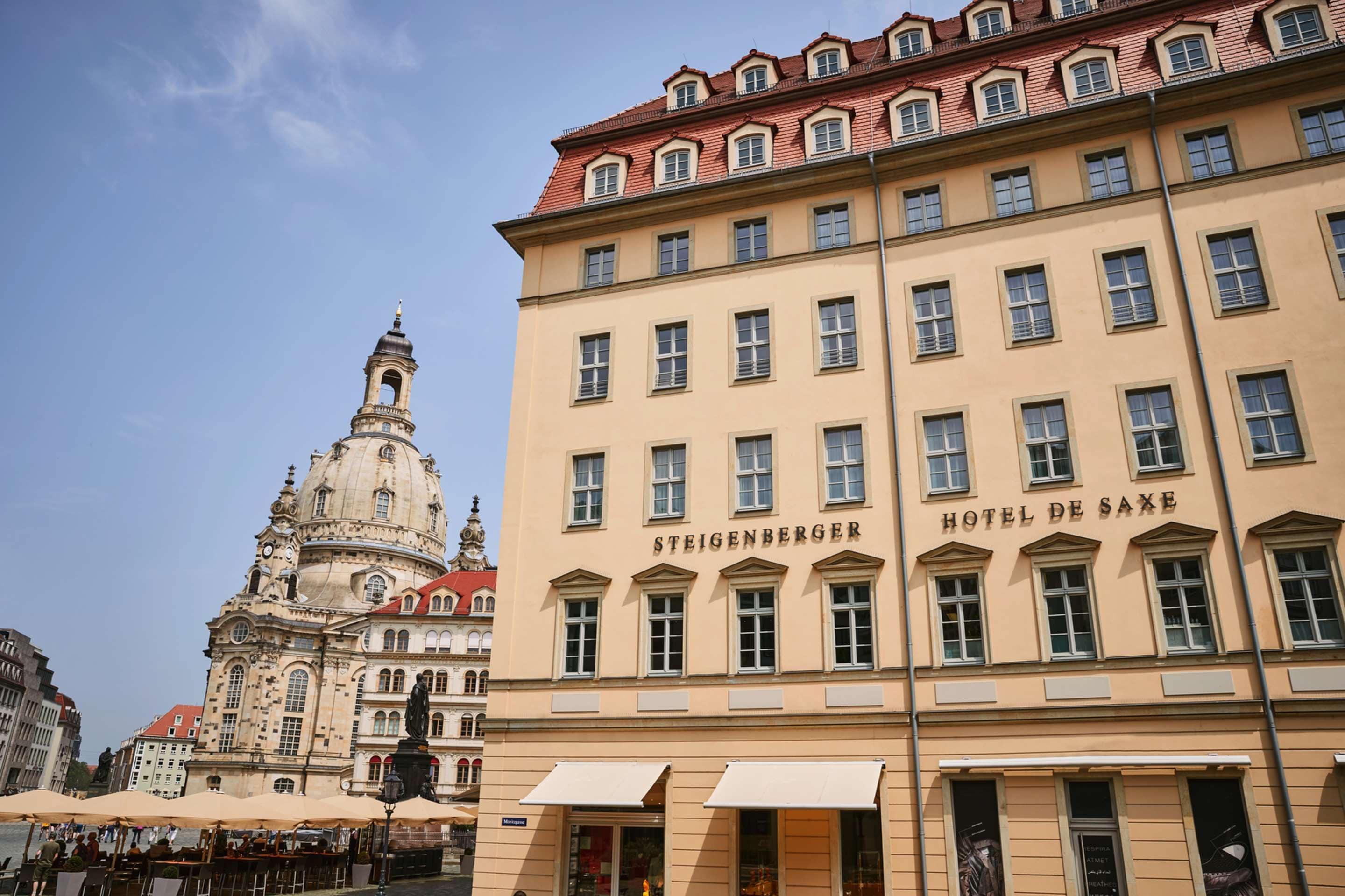 Un edificio histórico con el letrero “STEIGENBERGER HOTEL DE SAXE” y una torre destacada con cúpula.