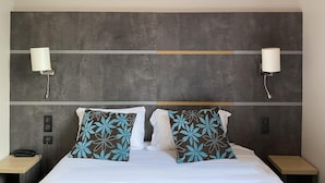 A hotel room with a large bed, two bedside tables, a telephone, and two wall-mounted lamps. - Timhotel Boulogne Rives de Seine (Boulogne-Billancourt)