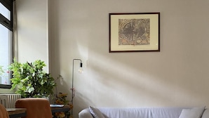 A living room with a sofa, two armchairs, a coffee table, a floor lamp, a framed artwork, and a patterned rug. - Timhotel Boulogne Rives de Seine (Boulogne-Billancourt)