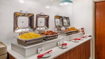 Un bufé con distintos alimentos y utensilios.
