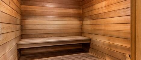 Uma sauna de madeira com bancos e degraus.