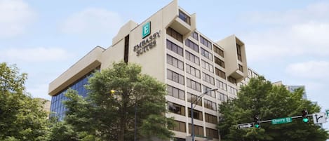 A modern building with a sign for 'Embassy Suites'. It features a multi-story structure with a flat facade and large windows.