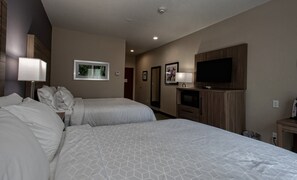 Una habitación de hotel con dos camas, un televisor y un cuadro en la pared.