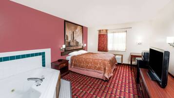 Habitación de hotel con una cama grande, televisión, escritorio, ventana con cortinas y un cuadro en la pared.