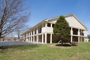 A two-story building with a symmetrical facade, multiple windows, and a central entrance. - Econo Lodge Sturbridge Route 20 (Sturbridge)