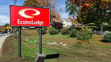 Senyal d'Econo Lodge amb una zona verda i arbres al fons.