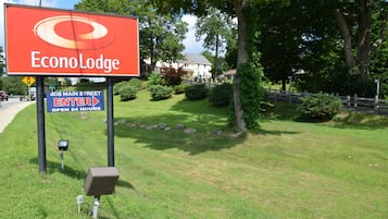Señal de Econo Lodge con letrero de 'abierto las 24 horas' y una flecha direccional.
