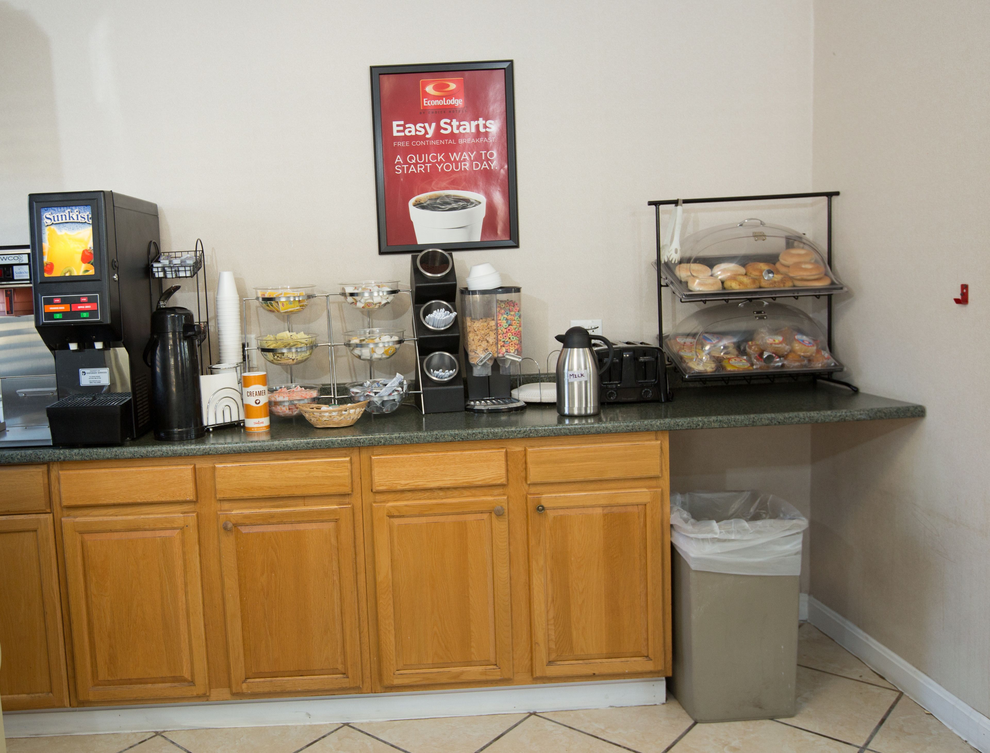Una kitchenette equipada con cafetera, tostadora, hervidor y una vitrina para pan.
