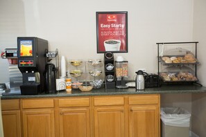 A breakfast bar with a coffee machine, a beverage dispenser, and a variety of food items. - Econo Lodge Sturbridge Route 20 (Sturbridge)