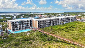 A hotel with a pool, multiple floors, and a view of the surrounding landscape. - Beacher's Lodge Oceanfront Suites (St. Augustine)