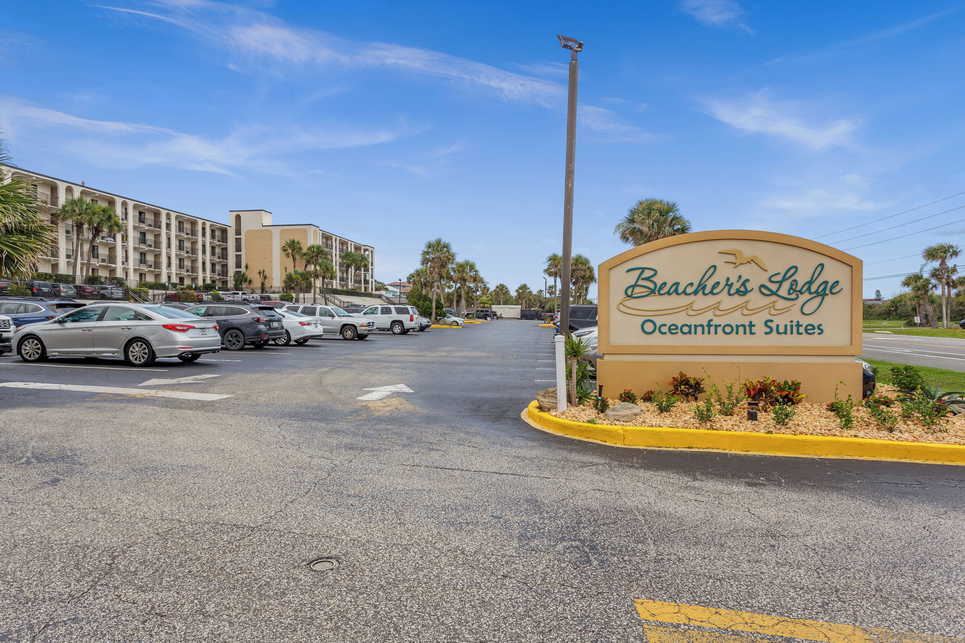 A parking lot with a sign for Beacher's Lodge Oceanfront Suites.