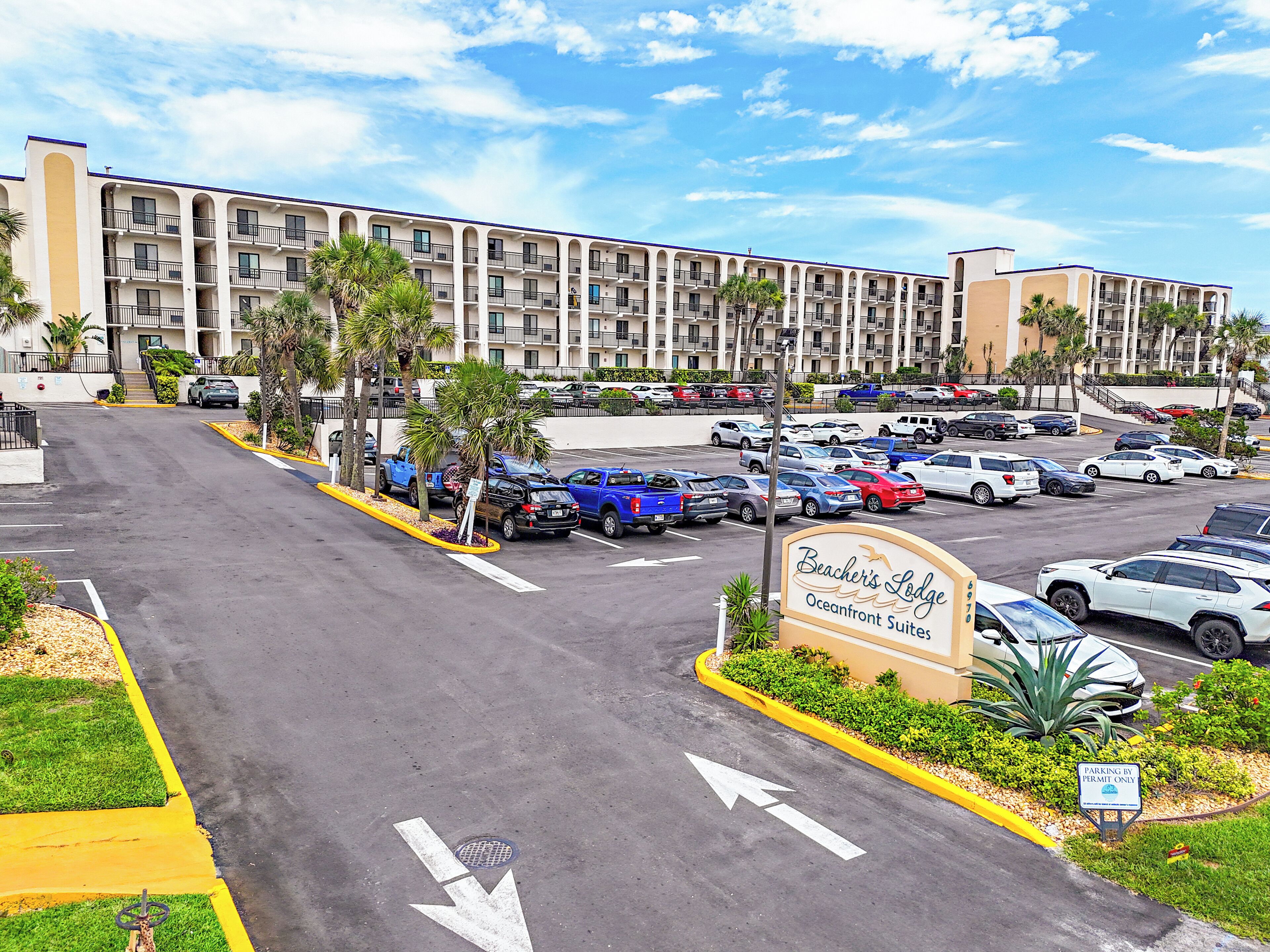 A parking lot with cars and a building in the background.