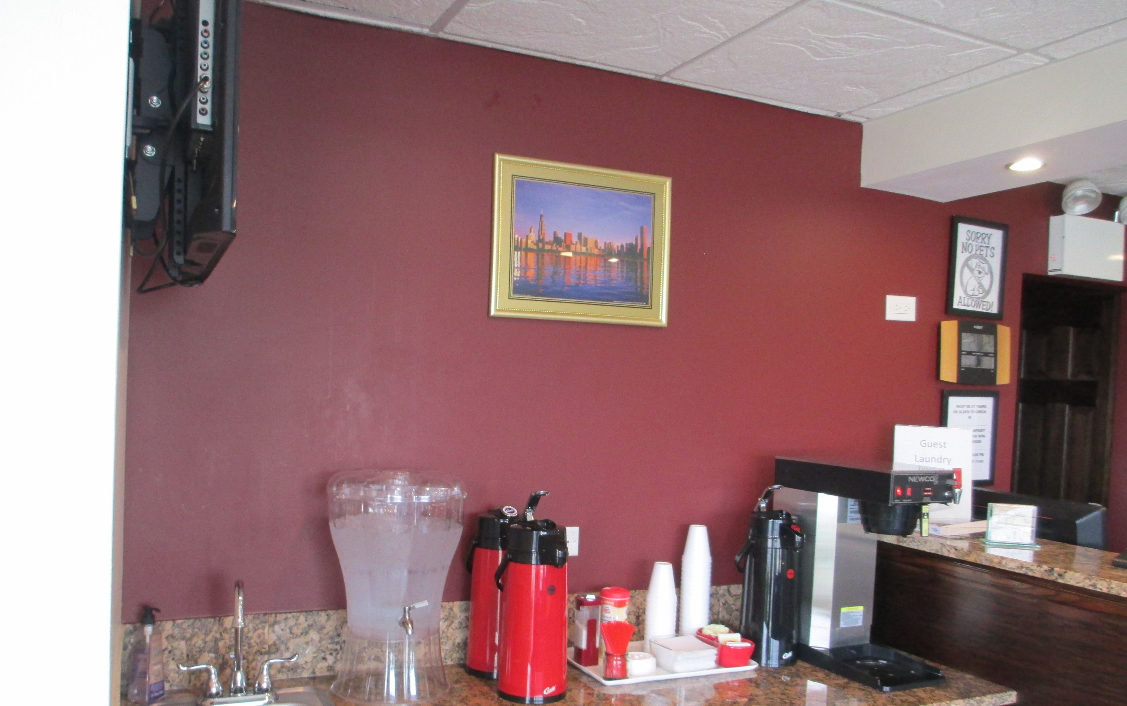 A hotel reception area with a marble counter, a large water dispenser, and a coffee machine.
