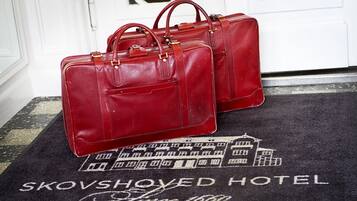 Two red leather bags on a doormat with the text "KOVSHORED HOTEL Since 1860".