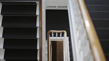 Una escalera con peldaños negros y barandilla blanca.