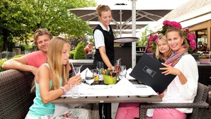 An outdoor dining area with tables, chairs, and umbrellas.
